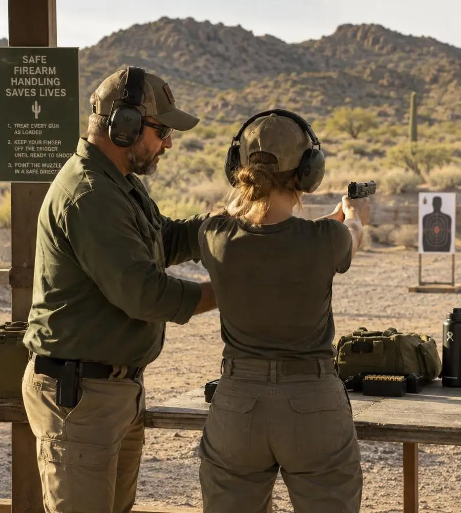 Safety and training — Bisbee Guns Adult instructor teaching safe firearm handling at an outdoor range